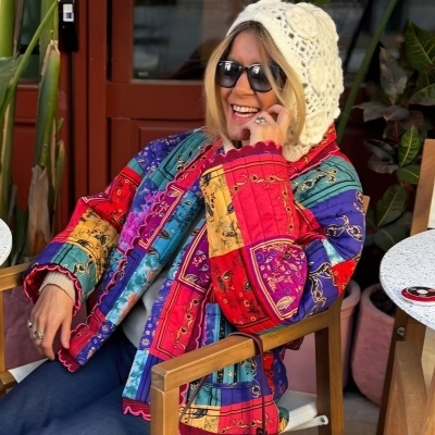 Mulher com casaco acolchoado colorido e gorro de tricô sentado em cadeira