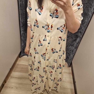 Vestido comprido creme com padrão de personagens a andar de trotinete e botões.