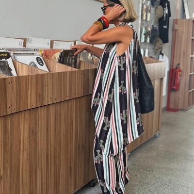 Mulher com vestido de cactos e riscas a escolher vinil numa loja