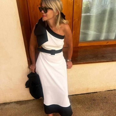 Vestido midi branco com detalhes pretos, mulher com óculos de sol em frente a parede
