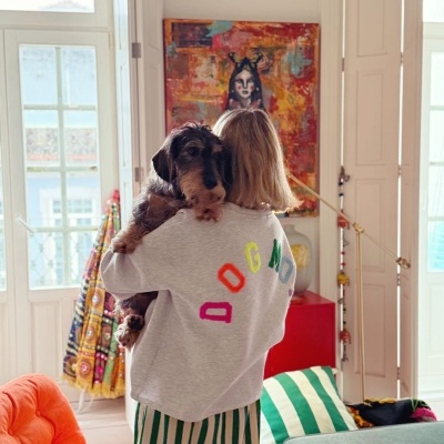Camisola cinzenta com letras coloridas DOG MOM nas costas e pessoa a segurar cão