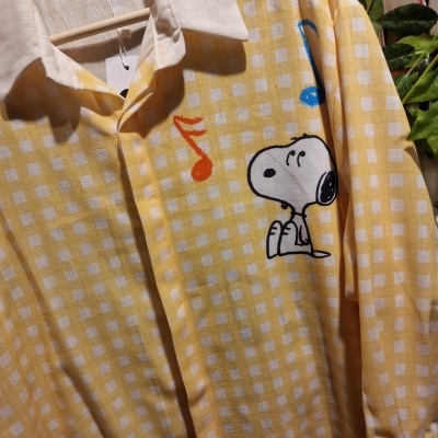 Camisa amarela com estampado Snoopy e notas musicais