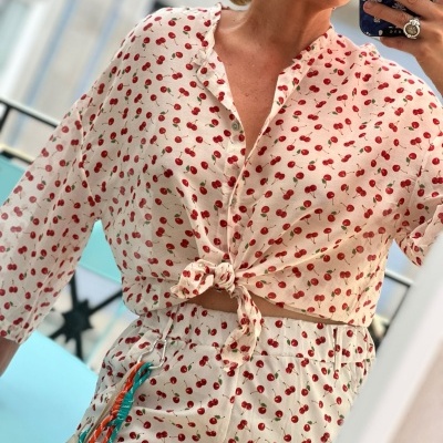 Conjunto de camisa e calças brancas com padrão de cerejas vermelhas