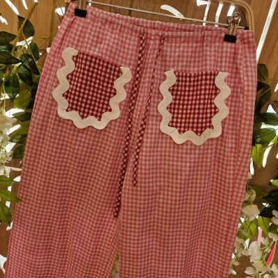 Calças vichy vermelho e branco com bolsos decorados e cordão na cintura