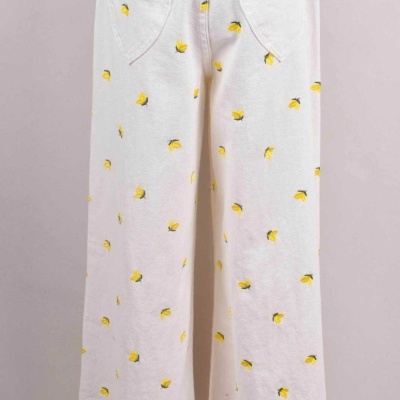 Calças largas brancas com flores amarelas e bolsos em forma de coração