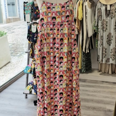 Vestido com padrão colorido de rostos femininos em manequim dentro de loja de roupa