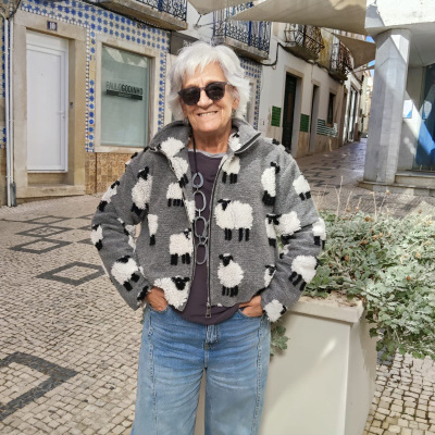 Casaco cinzento com ovelhas brancas e pretas usado numa rua alfacinha.