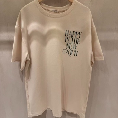 T-shirt creme com texto preto pendurada numa cabide de madeira