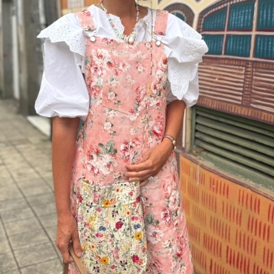 Vestido cor-de-rosa floral com blusa branca de mangas bufantes e bolsa de tecido floral.