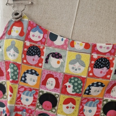 Vestido colorido com padrão de rostos femininos estilizados em quadrados