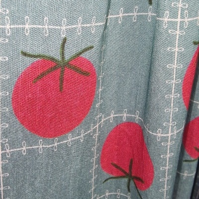 Tecido azul com padrão de tomates vermelhos e linhas brancas decorativas
