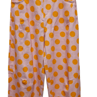 Calças cor-de-rosa com bolinhas laranja penduradas num cabide