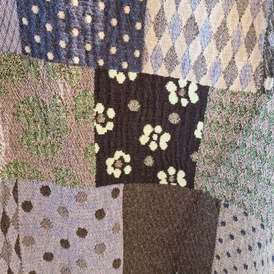 Tecido patchwork com várias texturas e padrões em tons azuis, verdes, castanhos e beges