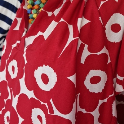 Vestido vermelho e branco com padrão floral em manequim e colar colorido