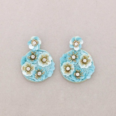 Brincos florais azuis com pérolas e miçangas em fundo cinza claro