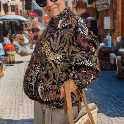 Mulher com casaco estampado animal print, calças cinza e bolsa de palha LOEWE