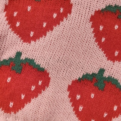 Malha rosa com padrão de morangos vermelhos tricotados