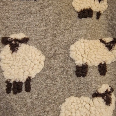 Tecido cinza com ovelhas felpudas em lã branca e castanho escuro