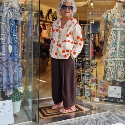 manequim feminino veste camisa branca com bolas vermelhas e calças castanhas em loja de roupa