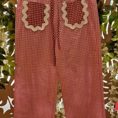 Calças largas xadrez rosa e branco com bolsos decorados