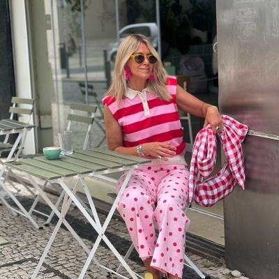 Mulher sentada ao ar livre com roupa colorida e óculos de sol