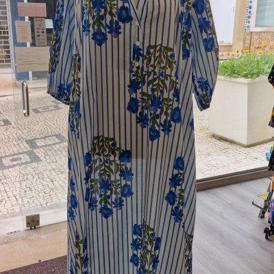 Vestido riscas azuis e flores azuis exibido em manequim com colar