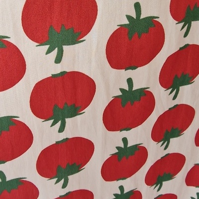 Tecido branco estampado com tomates vermelhos e folhas verdes