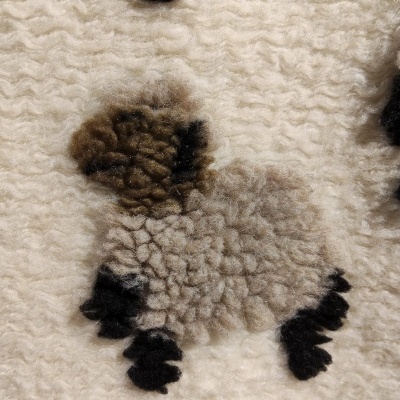 Tecido branco com padrão felpudo de ovelha em bege, castanho e preto