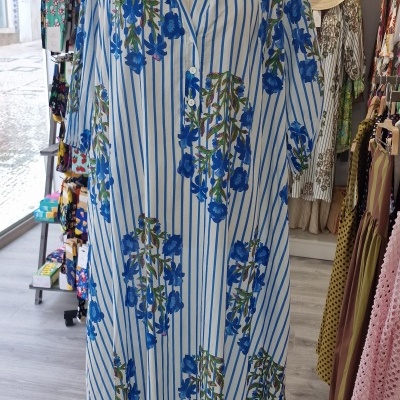 Vestido riscado azul e branco com flores azuis em manequim numa loja
