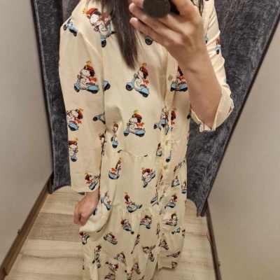 Vestido comprido creme com padrão de desenhos animados a andar de mota.