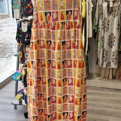 Vestido colorido com estampa em quadrados com ilustrações em manequim numa loja