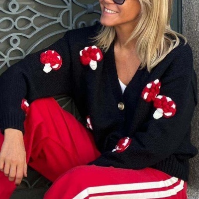 Casaco preto com cogumelos vermelhos e brancos e calças vermelhas com riscas brancas