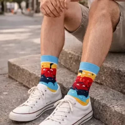 Meias coloridas com padrões de monstros e ténis brancos em ambiente exterior urbano