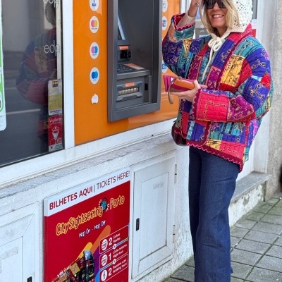 Mulher com casaco colorido junto a máquina de bilhetes City Sightseeing Porto