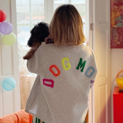 Pessoa de costas com casaco cinzento DOG MOM e cão pequeno