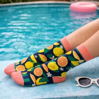 Meias coloridas com padrão de frutas cítricas usadas junto a piscina