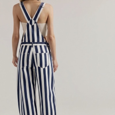 Macacão riscado azul e branco com alças ajustáveis visto de costas.