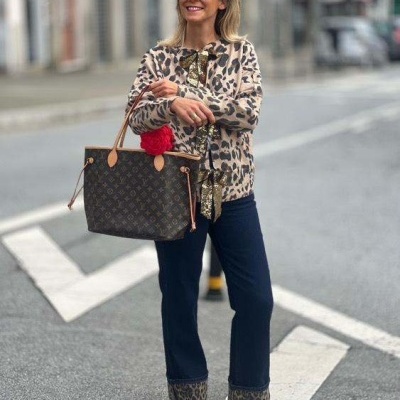 Mulher com roupa com padrão animal print e bolsa monogram