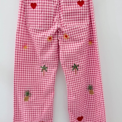 Calças compridas rosa e branco com bordados de corações, palmeiras, abacaxis e flores.