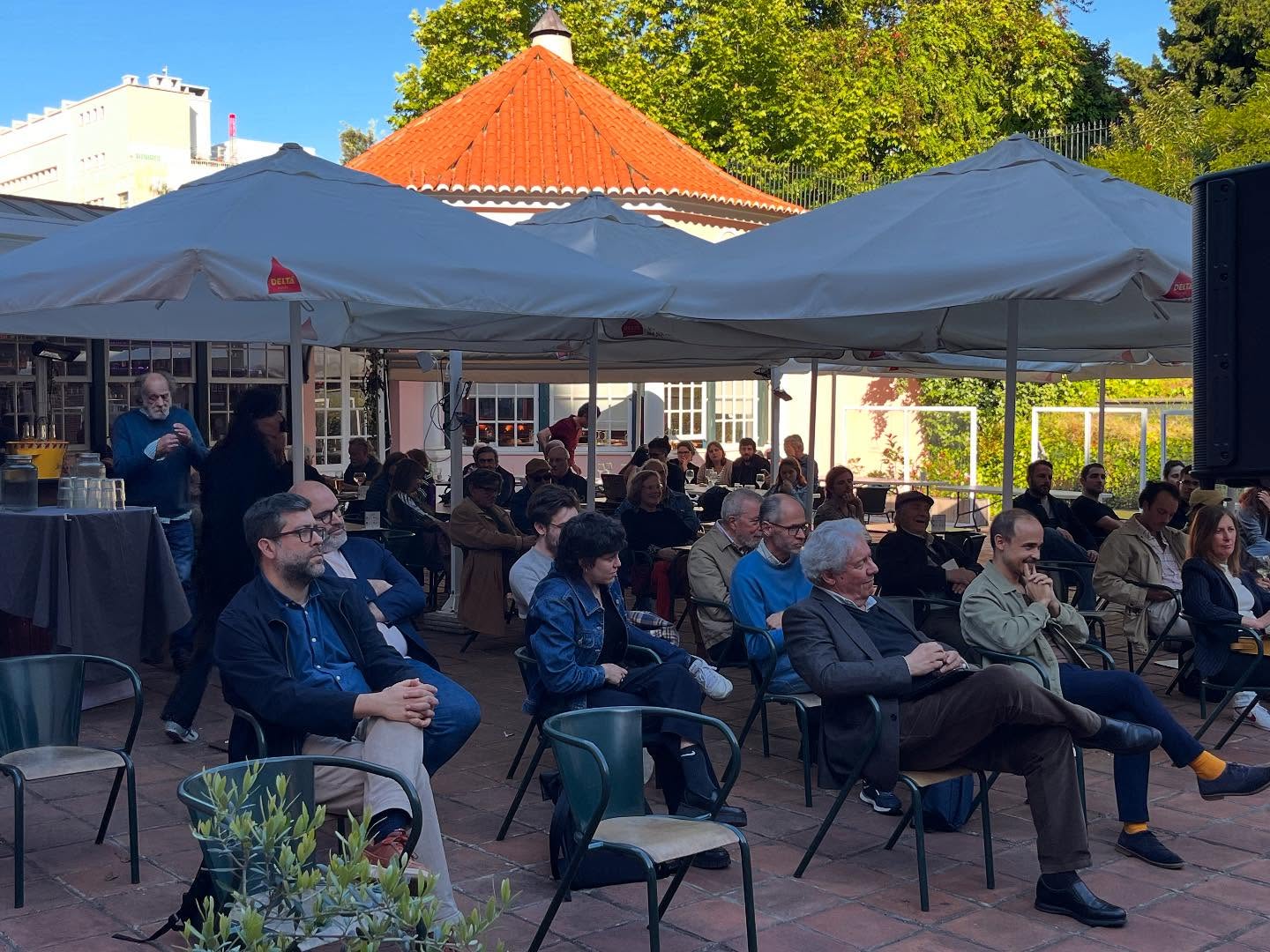 SOFIA E A EDUCAÇÃO SEXUAL ∙ EDUARDO GEADA Evento ao ar livre com pessoas sentadas sob toldos brancos