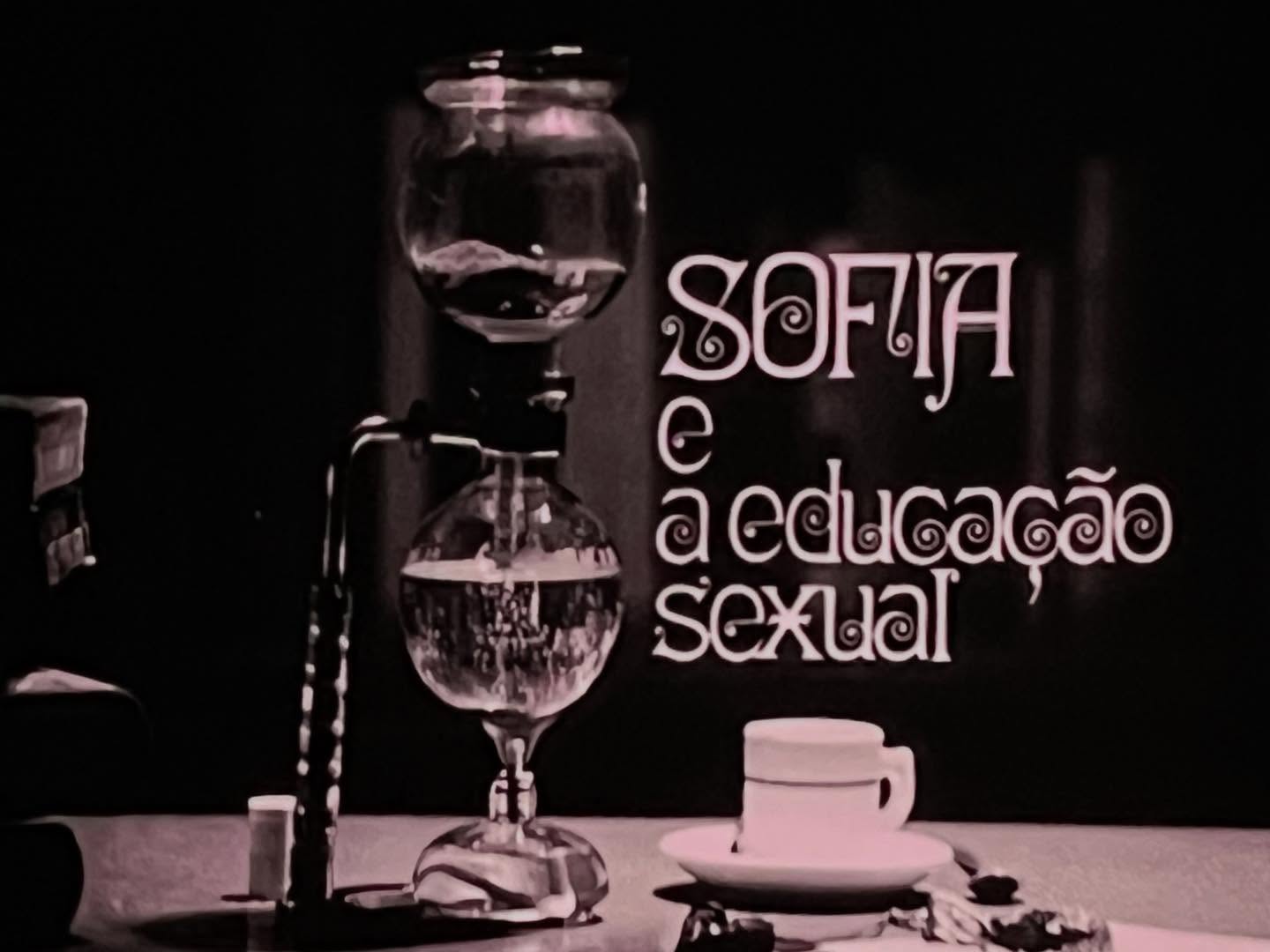 SOFIA E A EDUCAÇÃO SEXUAL ∙ EDUARDO GEADA Cafeteira de vidro, chávena branca, texto 'SOFIA e a educação SEXUAL' em fundo escuro