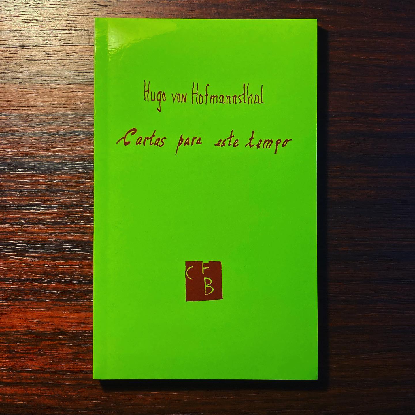 CARTAS PARA ESTE TEMPO • HUGO VON HOFMANNSTHAL Livro verde lima com texto castanho sobre mesa de madeira escura