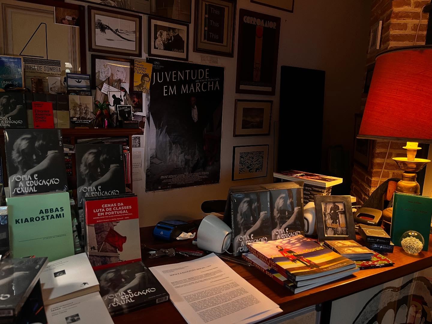 SOFIA E A EDUCAÇÃO SEXUAL ∙ EDUARDO GEADA Mesa de madeira com livros e abajur vermelho
