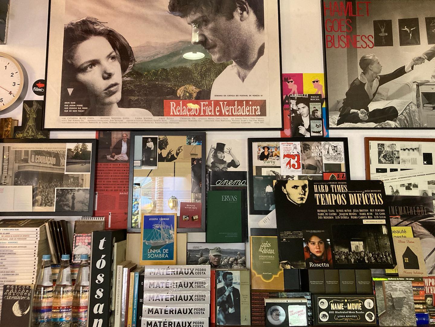 ERVAS ∙ YASUJIRO OZU ∙ JOÃO MIGUEL FERNANDES JORGE ∙ RUI VASCONCELOS ∙ RITA AZEVEDO GOMES Parede com posters de cinema e prateleiras com livros e caixas