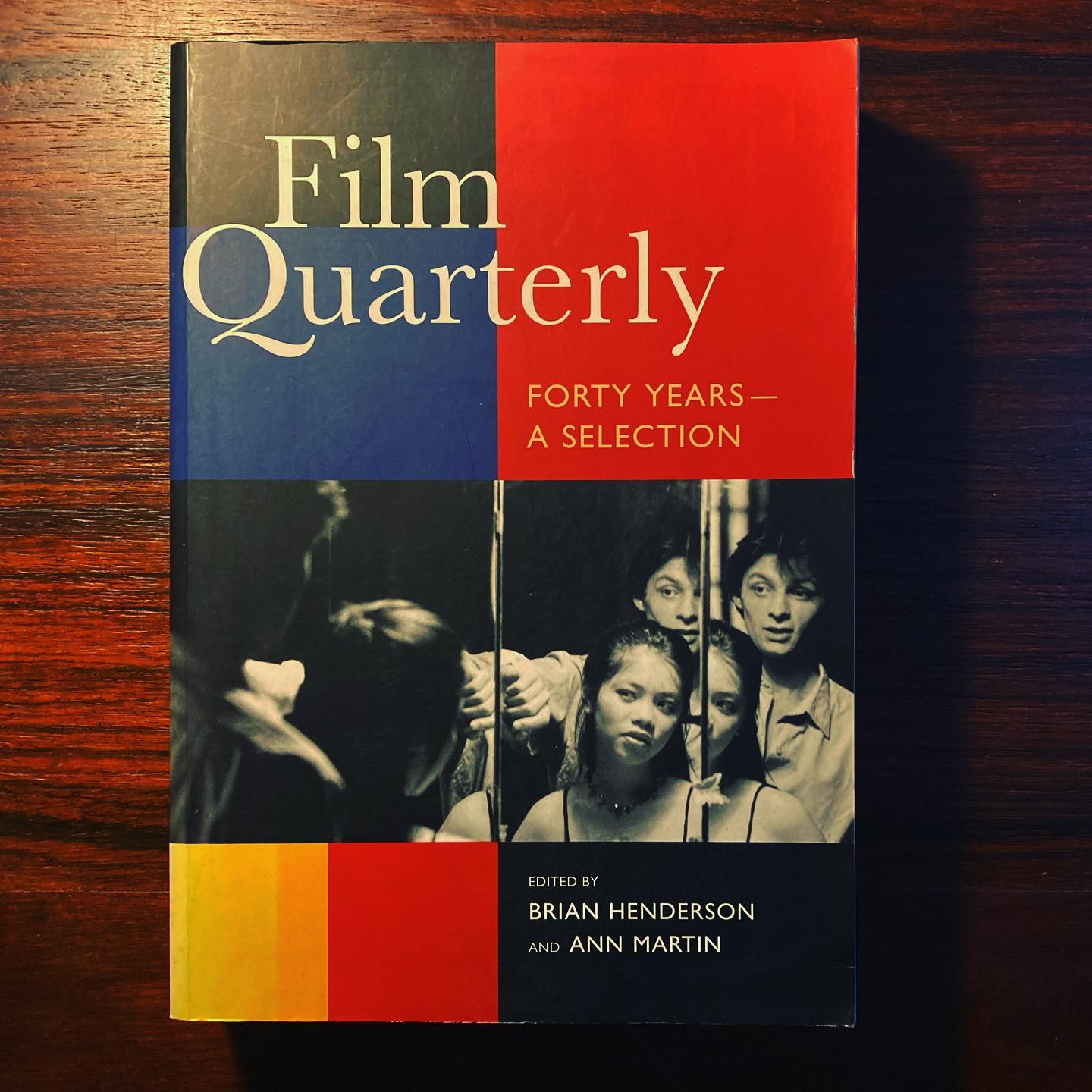 FILM QUARTERLY • FORTY YEARS - A SELECTION • BRIAN HENDERSON & ANN MARTIN (ED.) Capa de livro Film Quarterly com cores azul, vermelho, amarelo e preto e fotografia a preto e branco de quatro pessoas.