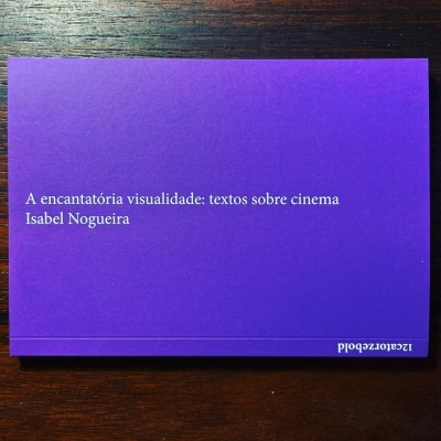 Livro roxo com texto branco sobre uma superfície de madeira escura