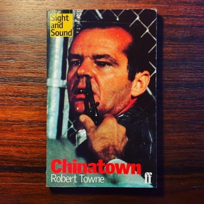 Capa de livro 'Chinatown' de Robert Towne com homem segurando arma
