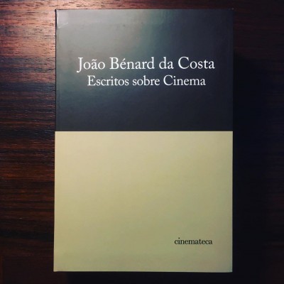 Livro 'João Bénard da Costa Escritos sobre Cinema' com capa preta e creme sobre mesa de madeira escura