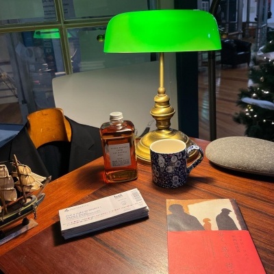 Mesa de madeira com diversos objetos e uma lâmpada verde acesa