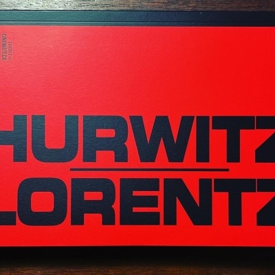 Livro vermelho com título preto grande sobre mesa de madeira